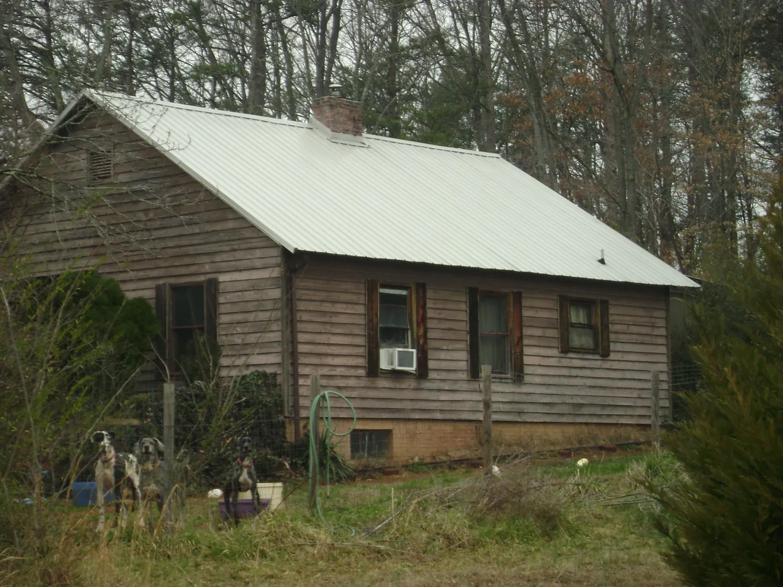 White metal roof on an old wood sided farmhouse, from a Asphalt Shingle Roof Repair job in Leesville